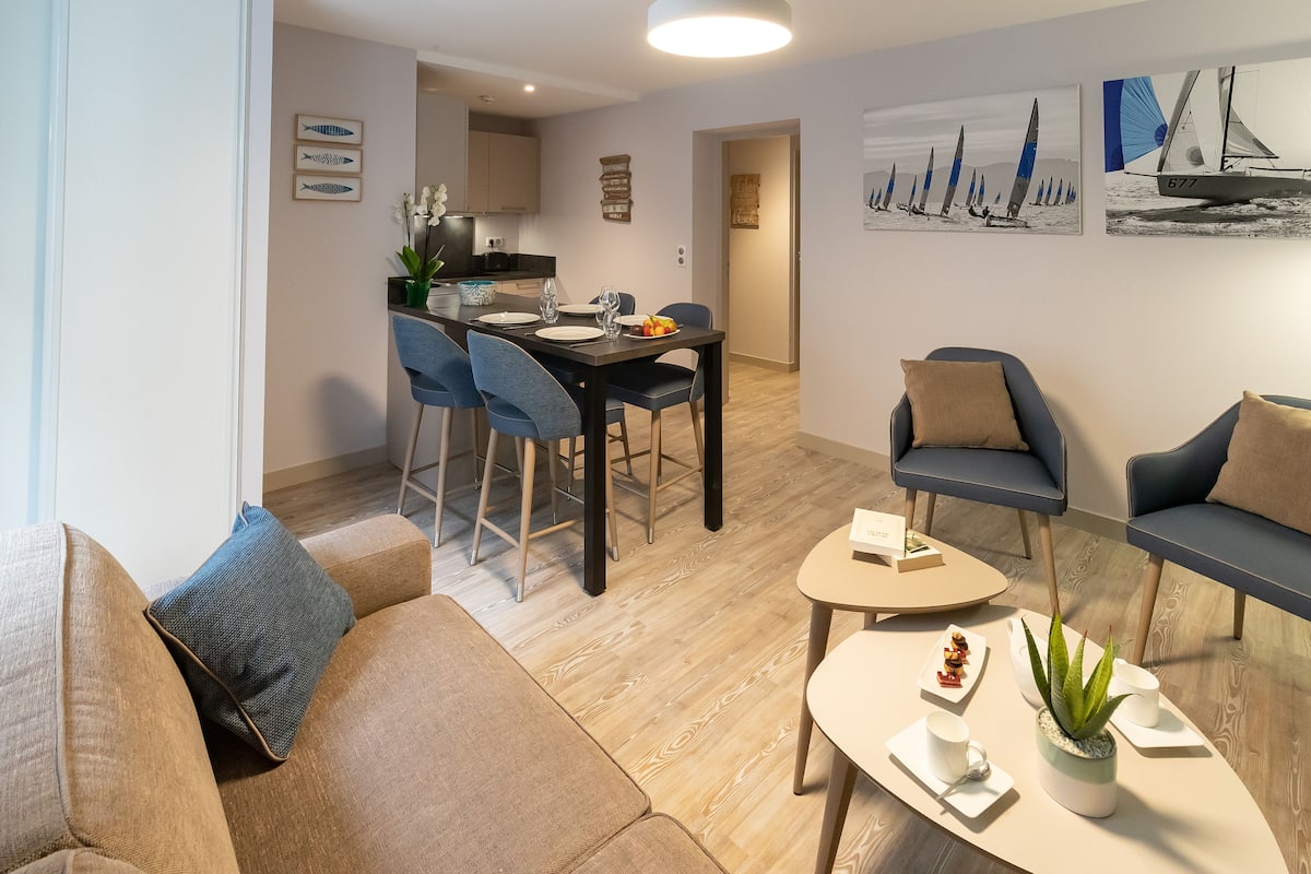 Een moderne woonkamer met een bank, een salontafel en een eethoek met stoelen en een tafel.