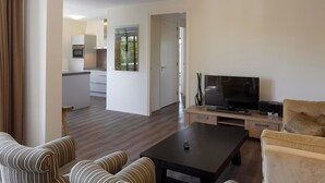 Ein modernes Wohnzimmer mit einem Flachbildfernseher, einem Couchtisch und gestreiften Sofas.