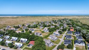 An aerial view of a residential area with houses, roads, and a coastline. - Comfortable Bungalow With Dishwasher Near the Beach (Hollum)