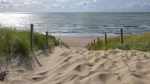 A sandy beach path leading to the ocean with a wooden fence on one side. - Modern Apartment 500 m From the Centre of Scheveningen (The Hague)