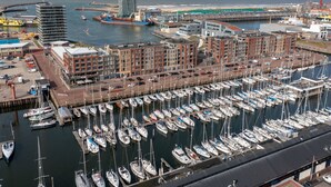 A marina with numerous boats docked, surrounded by modern buildings and a clear view of the sea. - Modern Apartment 500 m From the Centre of Scheveningen (The Hague)