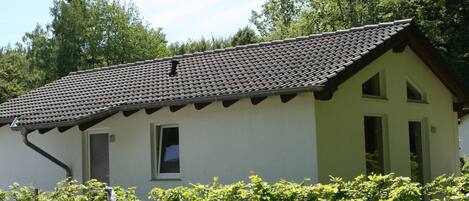Een laag gebouw met pannendak, een klein raam en een deur.
