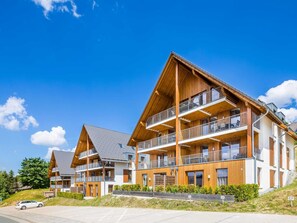 A modern multi-story hotel with wooden balconies and a sloped roof. - Spacious, Modern Apartment Near the Centre (Winterberg)