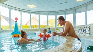 A swimming pool with a tiled interior, a child playing with a toy, and a mural of penguins on the wall. - Beautiful House With Sauna Near Ijsselmeer (Medemblik)