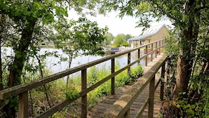 A wooden bridge over water with a building in the background. - Villa Oesterdam Comfort 8 Persons (Tholen)