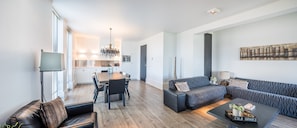 Uma sala de estar moderna com sofá, mesa de centro e área de jantar.