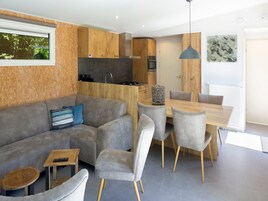 Ein modernes Wohnzimmer mit einem grauen Sofa, einem Holzesstisch und grauen Stühlen.