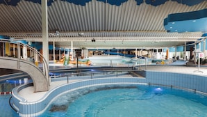 An indoor swimming pool with a curved design, a covered roof, and a slide. - Chalet at Roompot Beach Resort Near the Coast (Kamperland)
