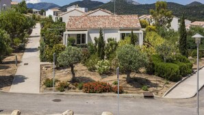 A residential area with houses, a paved walkway, and a road. - Holiday Park in Corsica With Terrace Homes (Belgodere)