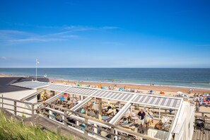 A beachside restaurant with outdoor seating overlooking the ocean. - Thatched Villa With Wifi, sea at 1 km in Cosy Domburg (Domburg)