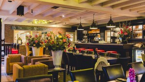 Een restaurantinterieur met zitjes, tafels en een bar.