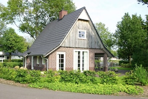 A single-story house with a sloped roof, brick exterior, and a small window. - Beautiful House With Garden (Hellendoorn)
