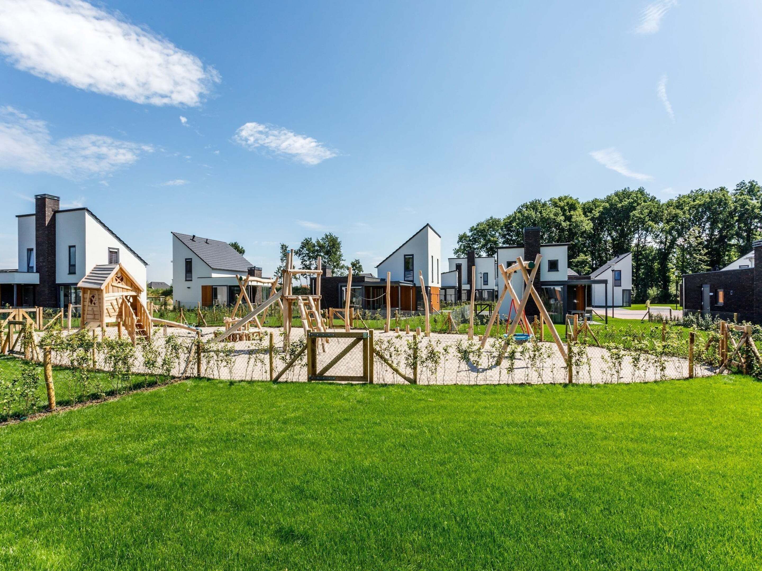 A residential area with modern houses, a playground, and a well-maintained lawn.