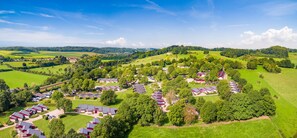 An aerial view of a residential area with houses and green fields.