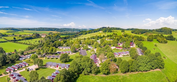 An aerial view of a residential area with houses and green fields.