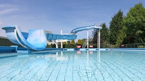 A swimming pool with a blue water slide and a clear blue sky. - Getaway With Covered Veranda (Enter)