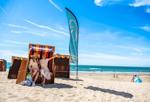 A beach scene with two beach chairs and a flag. - Comfortable Chalet With Dishwasher, Near the Sea in Egmond (Egmond aan den Hoef)