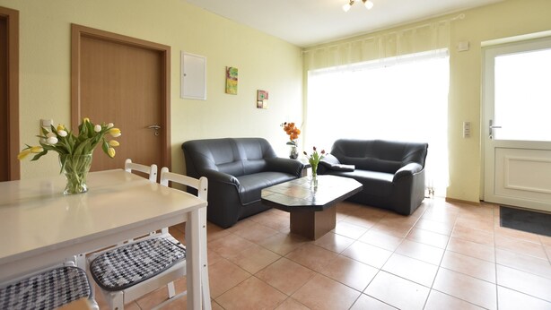 A living room with a dining table, two sofas, a coffee table, and a door. - Spacious Home, Zierow (Zierow)