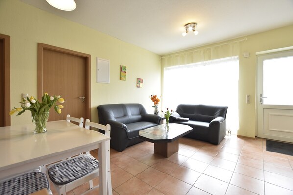 A living room with a dining table, two sofas, a coffee table, and a door. - Spacious Home, Zierow (Zierow)