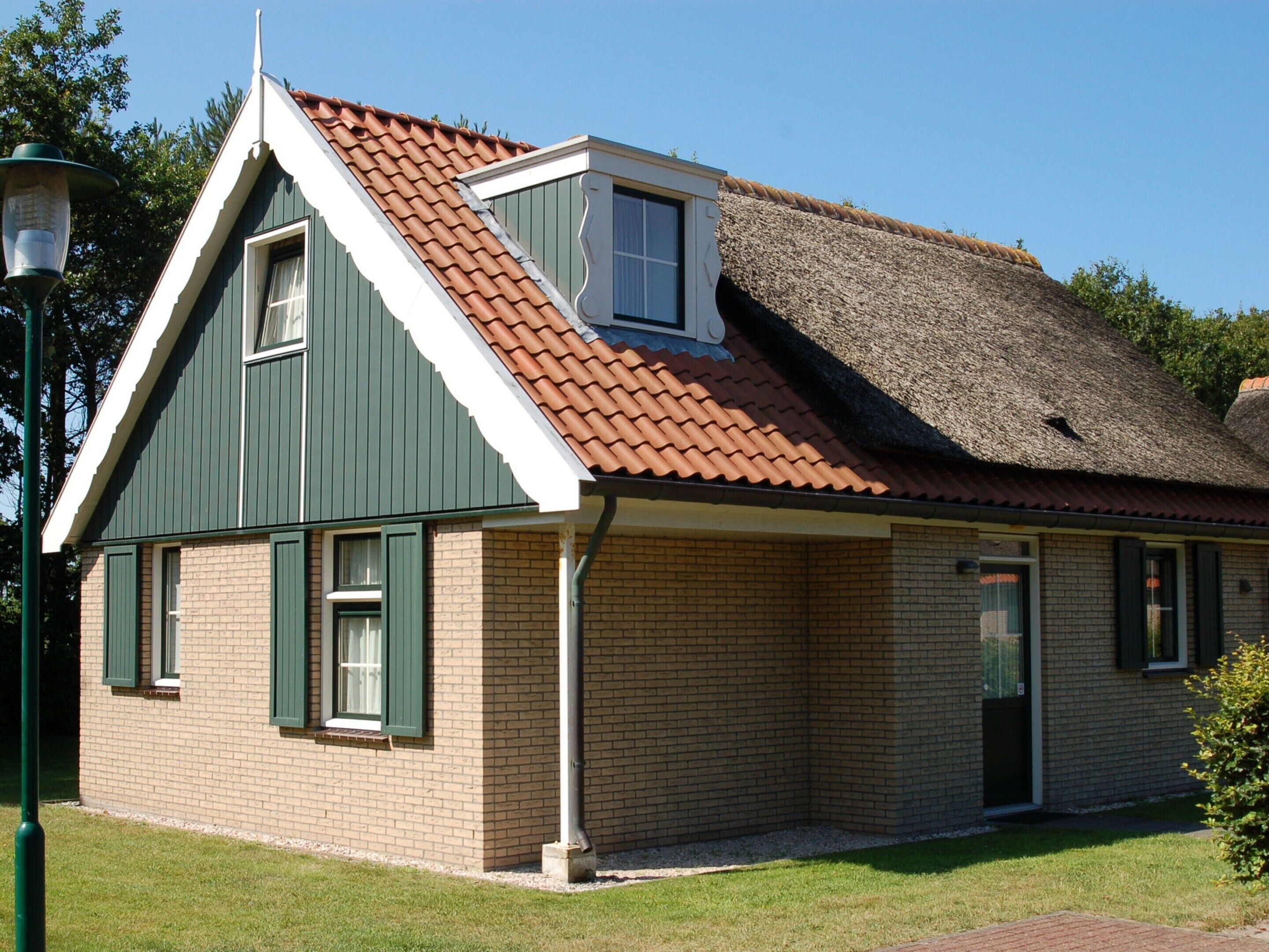 A single-story house with a sloped roof, a small attached garage, and a brick exterior.