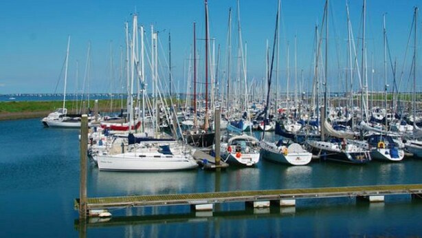 Una marina con numerosi cabinati ormeggiati a pontili di legno.