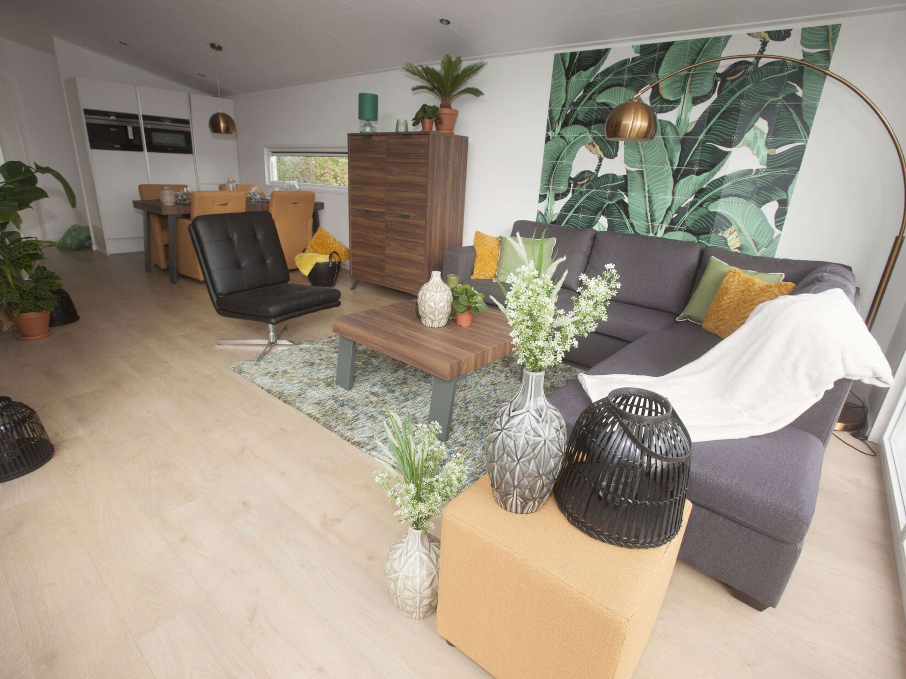 A modern living room with a sofa, armchair, coffee table, and decorative vases.