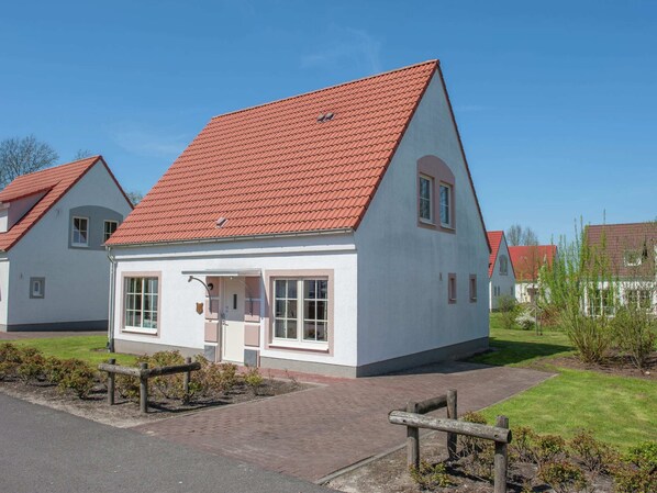 A single-story building with a red-tiled roof, a front entrance, and a small porch area. - Bubble Bath Villa Escape (Bad Bentheim)