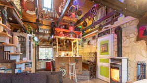 Un intérieur chaleureux avec un plafond en bois, une cheminée, un coin bar et un canapé.