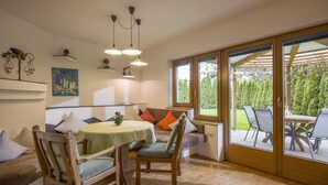 Un espace repas comprenant une table, des chaises et donnant sur l’extérieur.