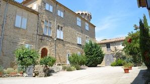 A stone building with multiple windows and a central arched entrance. - Provence Charm With Pool (Viens)