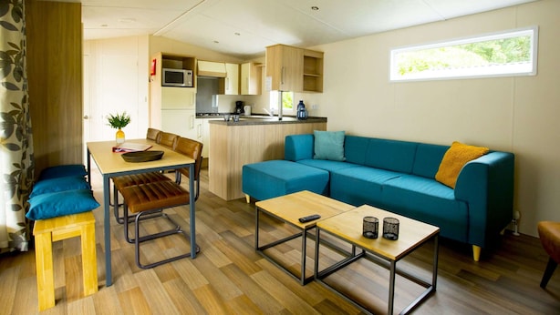 A compact living space with a kitchenette, a sofa, a dining table, and a coffee table.