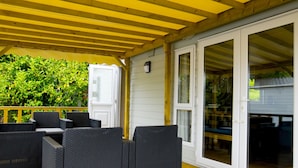 An outdoor patio with wicker furniture and a wooden ceiling.