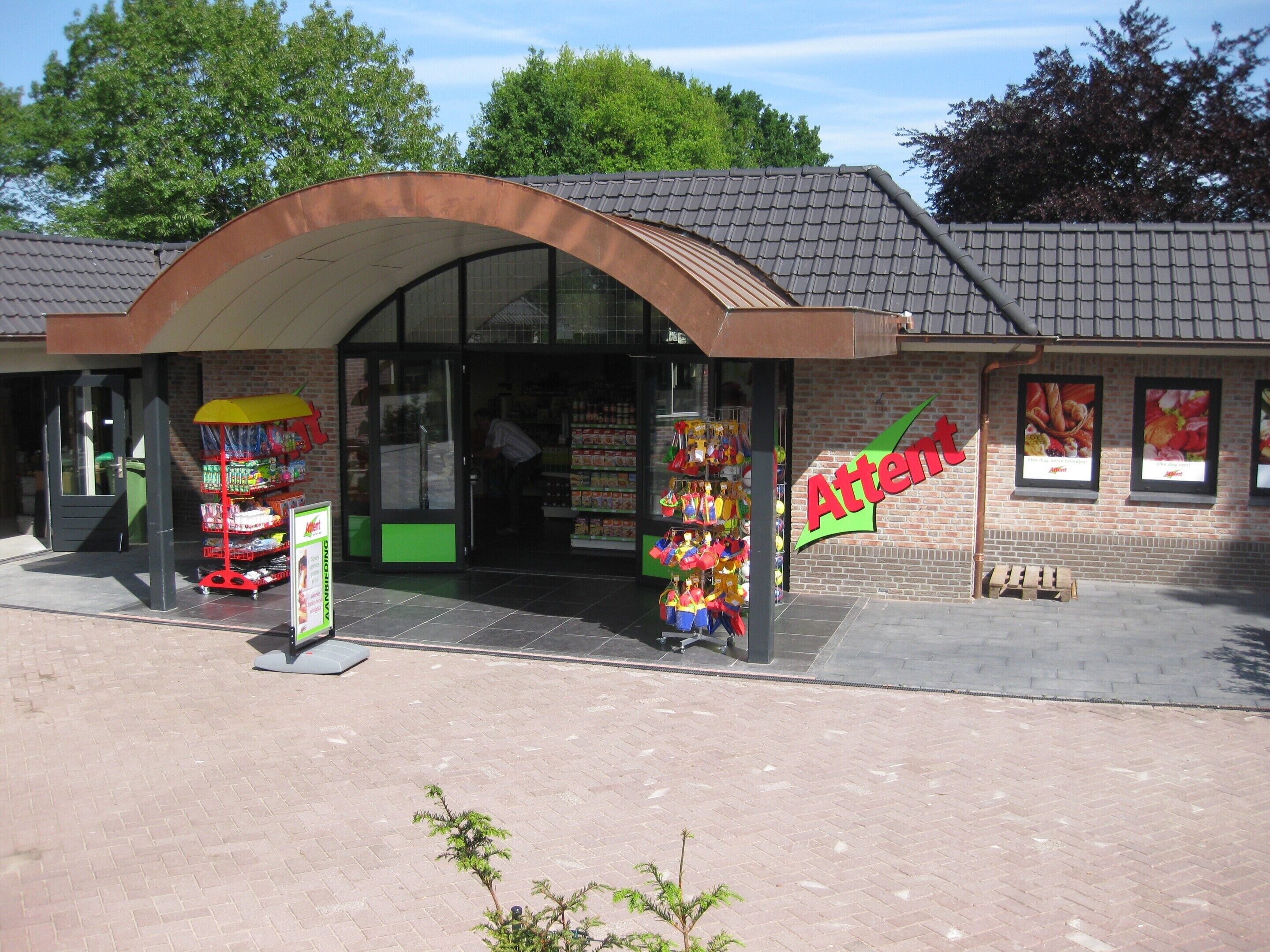 A store with a curved roof and a sign reading "Atten".