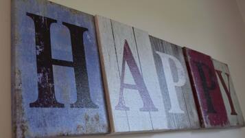 A wall with three wooden panels displaying the letters H, A, P, and Y in large, distressed fonts.