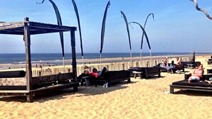 A beach with wooden structures, including a covered seating area and a long bench. - Spacious Lodge With 2 Bathrooms, Near the Sea (Zandvoort)