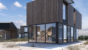 A modern, multi-story building with a wooden facade and large glass windows. - Spacious Lodge With 2 Bathrooms, Near the Sea (Zandvoort)