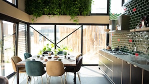 A modern kitchen with a dining area, large windows, and a view of the outside. - Special, Compound Group Accommodation, Near the Sea (Zandvoort)