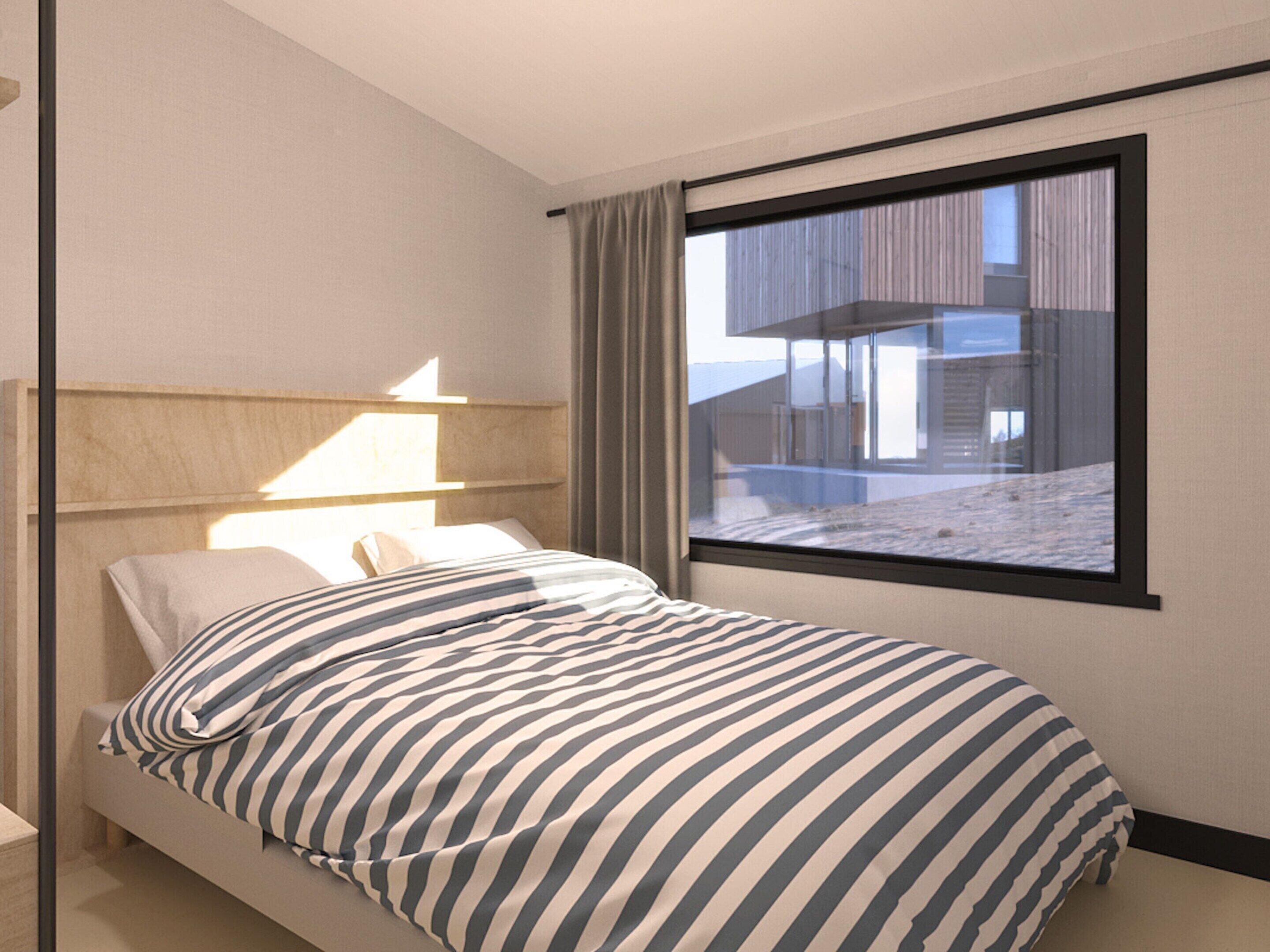 A modern hotel room with a bed, a nightstand, a lamp, and a large window offering a view of the building's exterior.