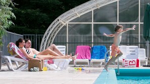 A swimming pool area with lounge chairs and a covered seating area. - Forest-edge Family Bungalow (Hoenderloo)