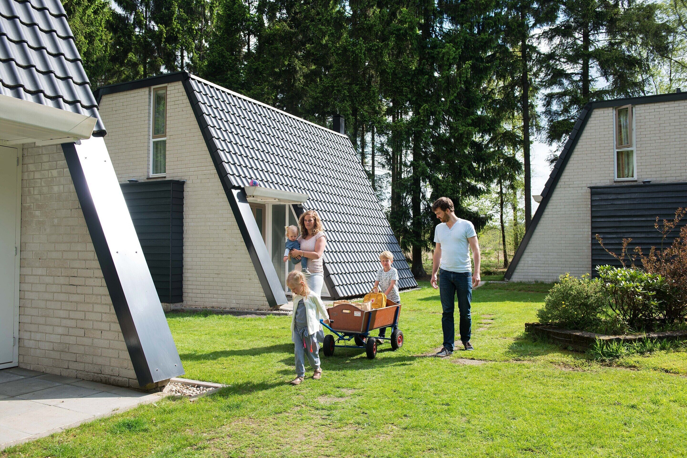 A residential area with a house featuring a sloped roof and a brick exterior.