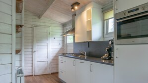 Una cocina con armarios blancos, una estufa y un lavabo.