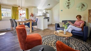 A modern living room with a dining area, a kitchen, and a loft bedroom. - Cozy Lodge With a Dishwasher in the Achterhoek (Winterswijk - Brinkheurne)