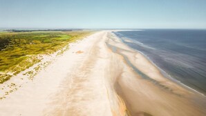 An aerial view of a beach with a long stretch of sand and a clear view of the ocean. - Thatched Holiday Home With two Bathrooms Near the Sea (Hollum)