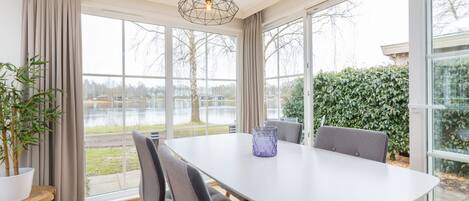 Un espace repas comprenant une table, des chaises et un luminaire suspendu.