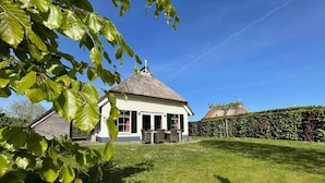 A house with a thatched roof, a lawn, and a hedge. - Country House with Terrace near Langweerder Wielen (Sint Nicolaasga)