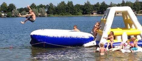 Een meer met opblaasbare waterconstructies en mensen die van watersporten genieten.