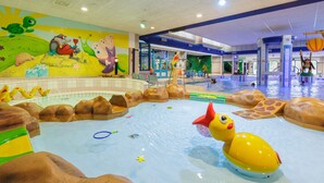 An indoor water play area with a pool, slides, and various play structures. - Forest Trails & Swimming Fun (Borger)