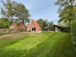 A house with a sloped roof, a covered porch, and a well-maintained lawn.