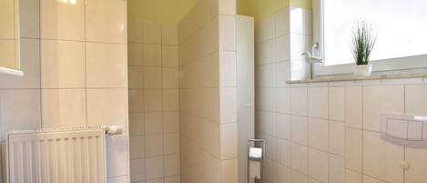 A bathroom with a shower, toilet, and sink.
