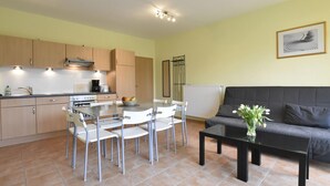 A compact living space with a kitchenette, dining area, and seating area.